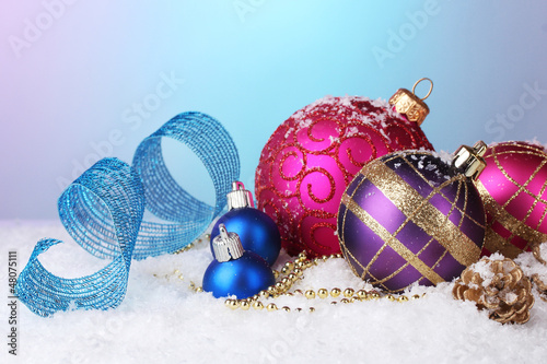 Photo: beautiful Christmas balls and cones on snow on bright beautiful Christmas balls and cones on snow on bright