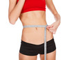 Woman measuring waist with a tape measure, isolated on white