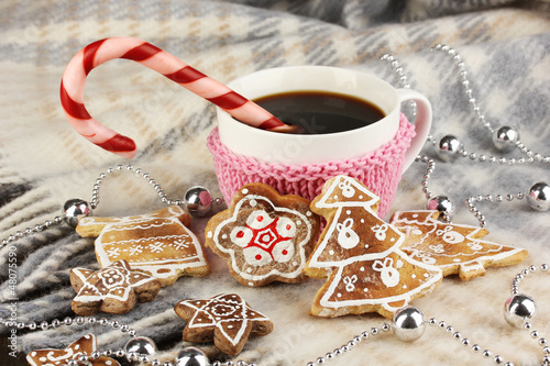 Photo: Cup of coffee with Christmas sweetness on plaid close-up Cup of coffee with Christmas sweetness on plaid close-up