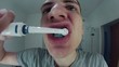 Funny looking young man brushing his teeth HD