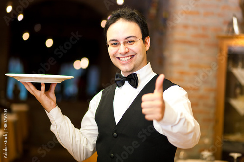 Photo: Positive waiter in an elegant restaurant Positive waiter in an elegant restaurant