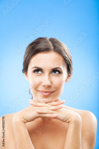 Photo: Thinking beautiful young woman, over blue Thinking beautiful young woman, over blue