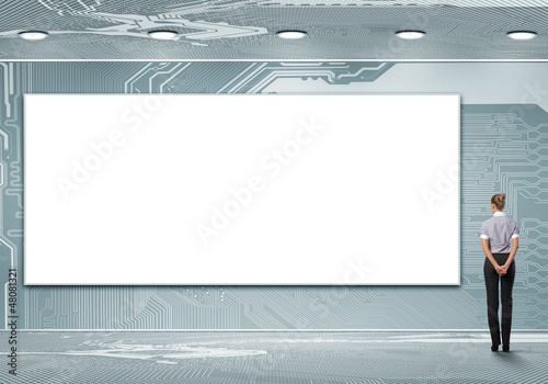Photo: Business person standing near a blank billboard Business person standing near a blank billboard