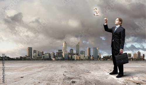 Photo: Image of a business man standing against cityscape Image of a business man standing against cityscape