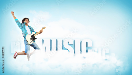 Photo: young man playing on electro guitar and jumping young man playing on electro guitar and jumping