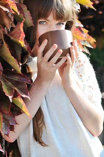 Photo: young woman with mug of hot drink young woman with mug of hot drink