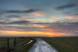 Country road towards horizon at sunrise