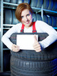 Apprentice showing thumb up for tire changing with blackboard