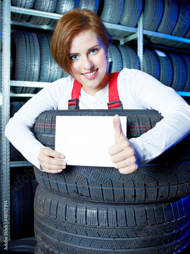 Photo: Apprentice showing thumb up for tire changing with blackboard Apprentice showing thumb up for tire changing with blackboard