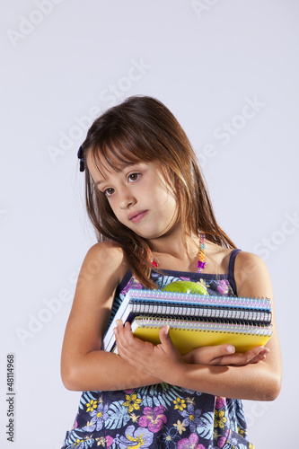 Photo: Little girl holding books and a apple Little girl holding books and a apple