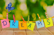 The word Dreams on wooden table on natural background