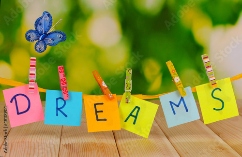 Photo: The word Dreams on wooden table on natural background The word Dreams on wooden table on natural background
