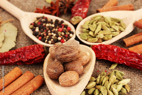 Photo: Nutmeg and other spices on sackcloth background Nutmeg and other spices on sackcloth background