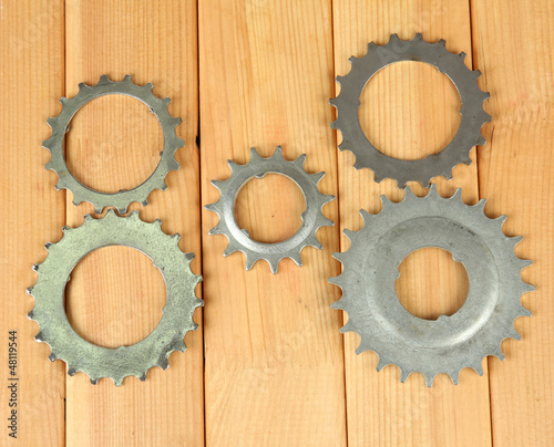 Photo: Metal cogwheels on wooden background Metal cogwheels on wooden background