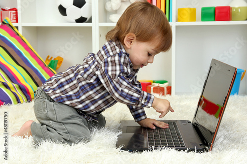 Photo: cute little boy and notebook in room cute little boy and notebook in room