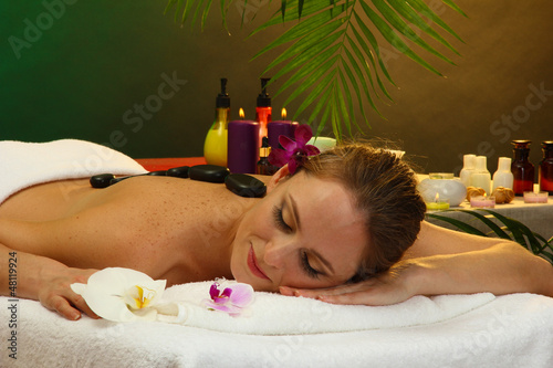 Photo: beautiful young woman in spa salon with spa stones, beautiful young woman in spa salon with spa stones,