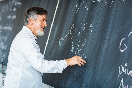 Photo: Senior chemistry professor writing on the board Senior chemistry professor writing on the board
