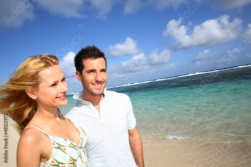 Photo: Young couple walking on a sandy beach Young couple walking on a sandy beach