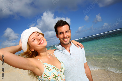 Photo: Young couple walking on a sandy beach Young couple walking on a sandy beach