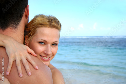 Photo: Beautiful girl embracing boyfriend at the beach Beautiful girl embracing boyfriend at the beach