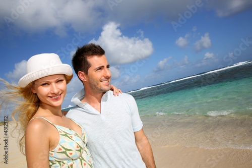 Photo: Young couple walking on a sandy beach Young couple walking on a sandy beach
