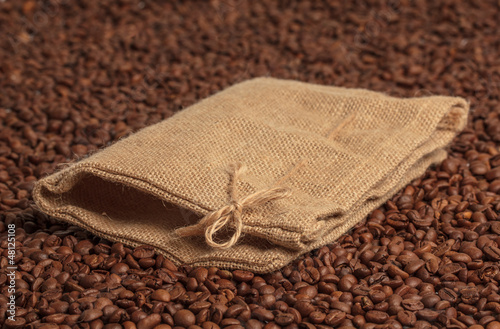 Photo: Coffee bag on coffee beans surface. Focused on bow. Coffee bag on coffee beans surface. Focused on bow.