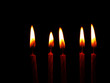 Five red candles burning in the dark - black background