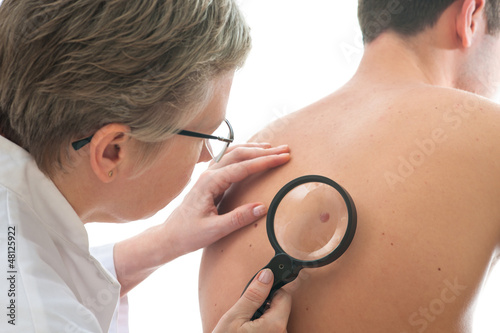 Photo: Dermatologist examines a mole Dermatologist examines a mole