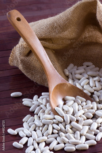 Photo: White beans - Cannellini (legumes) in a wooden spoon and bag White beans - Cannellini (legumes) in a wooden spoon and bag