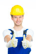 junger handwerker zeigt beide daumen hoch