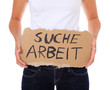 Foto: Frau hält Pappschild mit der Aufschrift Suche Arbeit Frau hält Pappschild mit der Aufschrift Suche Arbeit