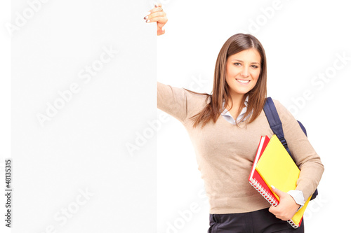 Photo: A smiling female student standing next to a billboard A smiling female student standing next to a billboard