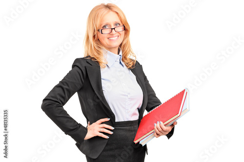 Photo: A smiling female teacher holding a notebook A smiling female teacher holding a notebook