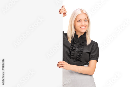 Photo: A smiling woman posing next to a blank panel A smiling woman posing next to a blank panel