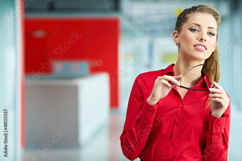 Photo: Portrait of happy smiling young businesswoman in office Portrait of happy smiling young businesswoman in office
