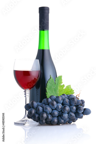 Photo: Bottle and glass of red wine with grapes branch isolated Bottle and glass of red wine with grapes branch isolated