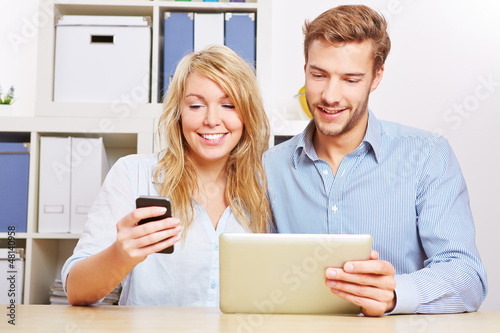 Photo: Paar synchronisiert Smartphone und Tablet PC Paar synchronisiert Smartphone und Tablet PC
