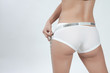 Photo : femme mesurant son tour de fesse en boxer blanc femme mesurant son tour de fesse en boxer blanc