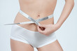 femme mesurant son ventre plat en boxer blanc