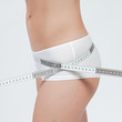 Photo : femme mesurant sa taille fine en boxer blanc femme mesurant sa taille fine en boxer blanc
