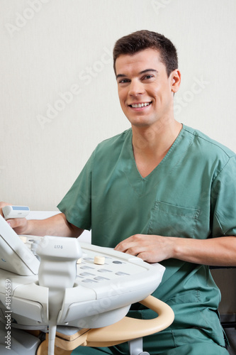 Photo: Male Technician Operating Ultrasound Machine Male Technician Operating Ultrasound Machine