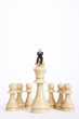 Businessman figurine sitting on top of king chess piece