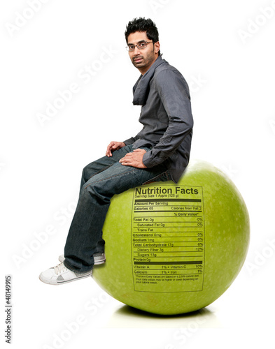 Photo: Man Sitting on Red Delicious Apple with Nutrition Label Man Sitting on Red Delicious Apple with Nutrition Label
