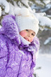 Portrait of a little girl's snow-covered tree