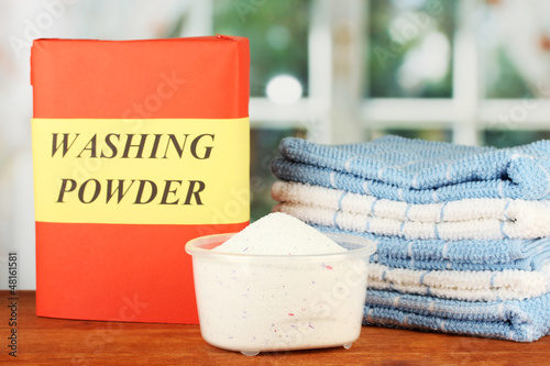 Photo: Box of washing powder with blue measuring cup and towels, Box of washing powder with blue measuring cup and towels,