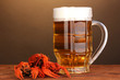 Tasty boiled crayfishes and beer on table on brown background