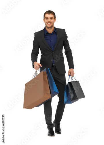 Photo: handsome man in suit with shopping bags handsome man in suit with shopping bags