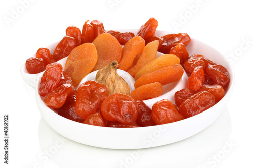 Photo: Dried fruits on plate isolated on white Dried fruits on plate isolated on white