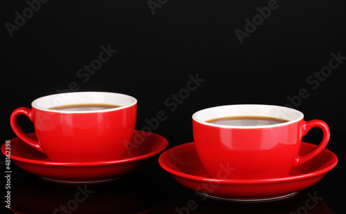 Photo: A red cups of strong coffee isolated on black A red cups of strong coffee isolated on black