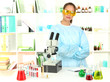 Young scientist looking into  microscope in  laboratory.